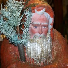 a close up of a statue with a tree in it's hand and a santa clause head