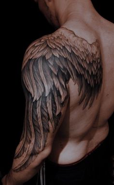 a man's back with an angel wing tattoo on his left arm and chest