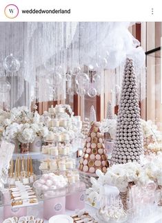 a table topped with lots of cakes and desserts covered in white frosted icing