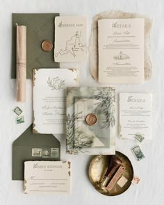 the wedding stationery is laid out on top of each other, including envelopes and stamps