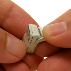 a person holding a tiny piece of money in their left hand, with the other end torn off