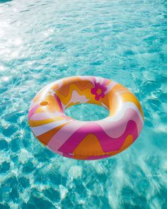 an inflatable ring floating on top of a pool filled with clear blue water