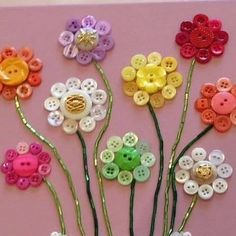 there are many different colored buttons on the flower stems, and one has a teddy bear in it