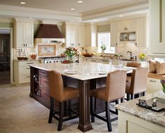 a large kitchen with an island in the middle and two chairs at the counter top