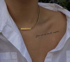 a woman wearing a white shirt has a gold bar on her chest that says, you're so much more