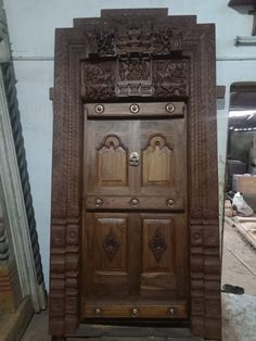 an old wooden door with ornate carvings on the front and side doors are being worked on