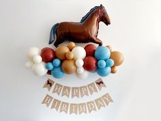 a birthday decoration with balloons and a horse