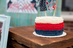 a red, white and blue cake sitting on top of a wooden table