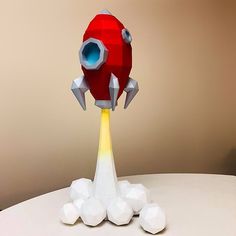 a paper model of a rocket ship sitting on top of ice cubes