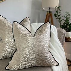 two pillows sitting on top of a couch