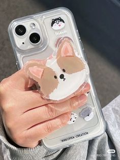 a person holding a phone case with a dog sticker on it