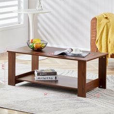 a coffee table with a bowl of fruit on top and a book sitting on it