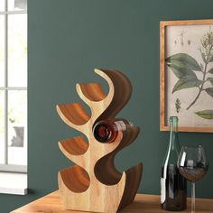 a wine bottle holder made out of wood with an abstract design on the top and bottom