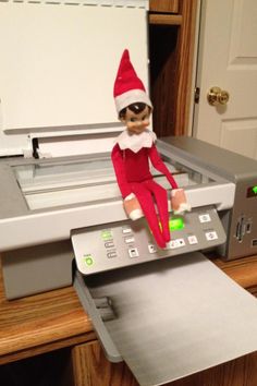 an elf is sitting on top of a printer