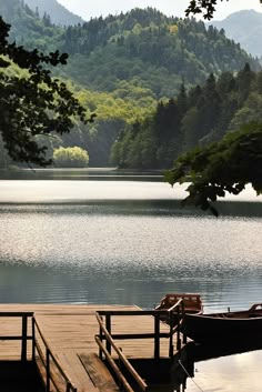 two boats are docked at the end of a dock on a lake with mountains in the background