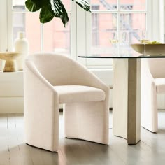 a white chair sitting in front of a glass table