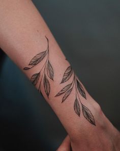 a woman's arm with leaves on it