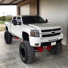 a white truck parked in front of a garage