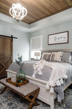 a bedroom with a bed, rugs and pillows on the floor in front of a wooden ceiling