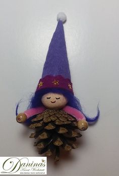 a purple gnome doll with a pine cone on its head