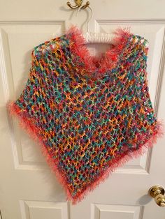 Add a touch of bohemian style to your little girl's outfit with this beautiful handmade poncho shawl. The pink and multi color and fringe accents give it a playful and fun look that is perfect for travel or casual occasions. The round neckline and pullover closure make it easy to wear and comfortable for all-day wear. Made with care in the United States, this sweater is a one-of-a-kind piece that your little girl will love. The crochet fabric type adds texture and interest to the garment, while the vintage style gives it a unique touch. It measure 25 inches wide and 22 inches in length. The head opening is 24 inches. Perfect for girls of all ages, this cape-style sweater is a must-have addition to any wardrobe. Multicolor Fringe Shawl For Spring, Multicolor Shawl With Tassels For Festival, Multicolor Tassel Shawl For Festival, Spring Multicolor Fringe Shawl, Spring Multicolor Shawl With Fringe, Spring Multicolor Tassel Shawl, One Size Bohemian Pink Poncho, One Size Yarn Poncho For The Beach, Bohemian Multicolor Shawl For Spring