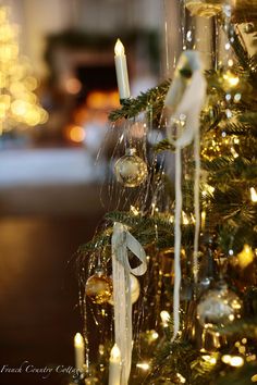 a christmas tree with candles and ornaments hanging from it