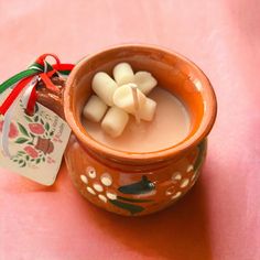 a small bowl filled with some kind of food on top of a pink table cloth