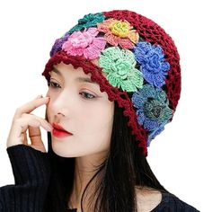 a woman wearing a multicolored crocheted hat with flowers on the brim