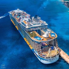 an aerial view of a large cruise ship in the middle of the ocean with blue water