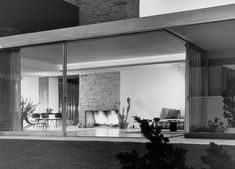 a black and white photo of a living room with sliding glass doors to the outside