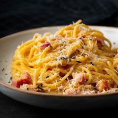 a plate full of pasta with meat and cheese on top, sitting on a table