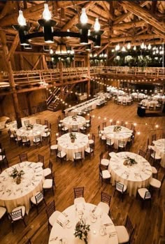 the inside of a barn with tables and chairs set up for an event or function