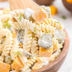 a wooden spoon filled with pasta salad