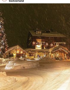 a large house covered in snow with christmas lights on it's windows and trees