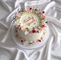 a white cake with pink and blue flowers on it