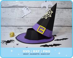 a purple witches hat sitting on top of a table next to a pumpkin and ghost