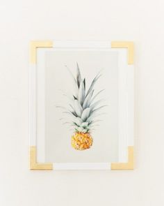 a pineapple in a frame on a white wall