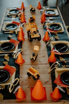 a table set up with construction themed plates and orange cones