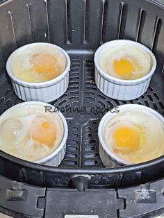 four eggs are being cooked in an air fryer