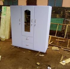 a white cabinet sitting in the middle of a room with construction materials scattered around it