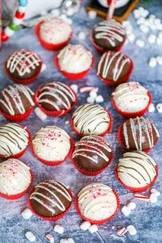 chocolate cupcakes with white frosting and sprinkles on a table