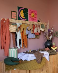 a room with clothes hanging on the wall and other items sitting on top of it