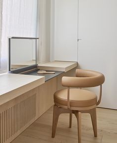 a chair sitting in front of a window next to a wooden desk and counter top