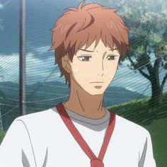 a young man in a white shirt and red tie standing next to a wire fence