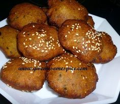 a white plate topped with muffins covered in sesame seeds