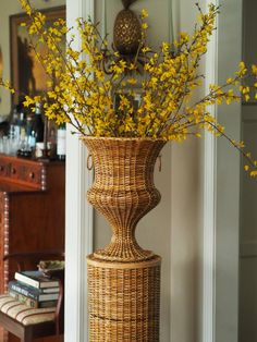 a tall vase with yellow flowers in it