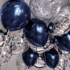 blue and silver balloons are hanging from the ceiling