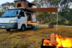 a camper van parked next to a fire pit