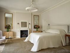 a bedroom with a white bed and fireplace