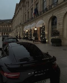 cars parked in front of a building with christmas lights